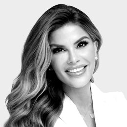 Black-and-white professional headshot of Dr. Dendy Engelman, a dermatologist, with long wavy hair, wearing a light-colored blazer.