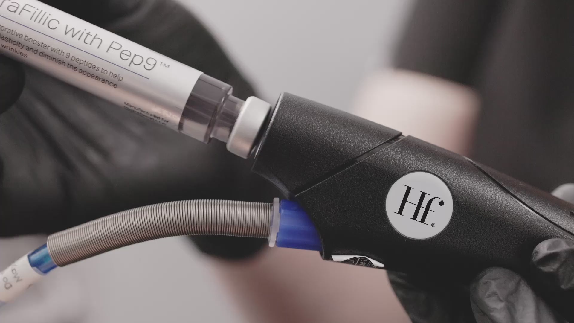 A Hydrafacial device fitted with a booster serum labeled “Fillic with Pepg™” being held in black gloves, showing the integration of targeted boosters into the treatment.